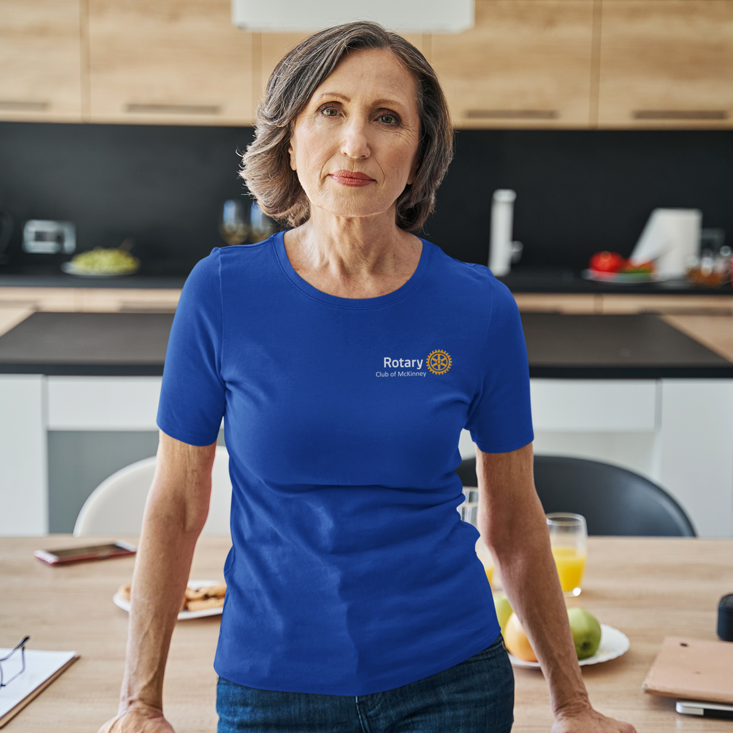Two people wearing blue Rotary shirts with text on a gray background