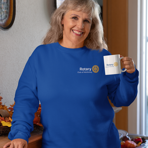 Woman wearing a blue sweatshirt with a Rotary logo, holding a matching mug.